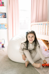 Little girl sitting on a bean bag in her bedroom located in Orange County, California