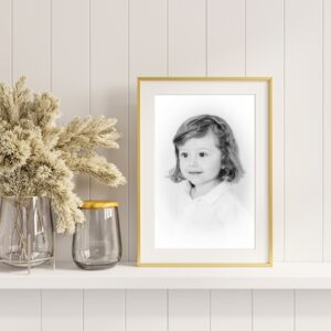 A framed image of a young boy sits on a shelf. The portrait is a black and white Orange County Personality Portraits and an heirloom piece. It was taken by Amy Captures Love.