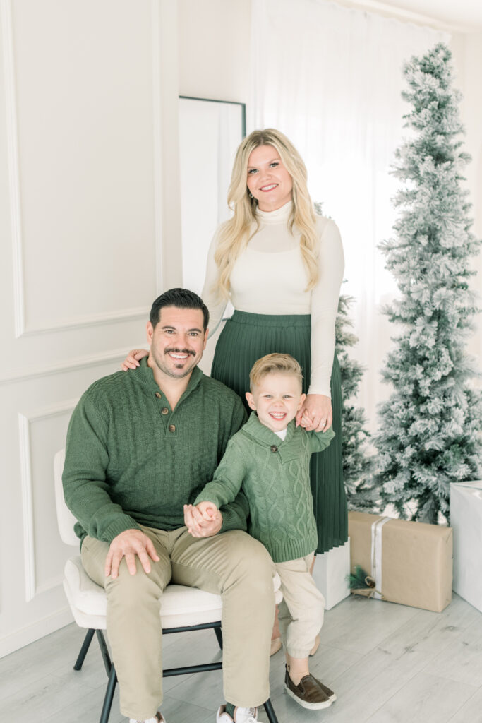 Family of 3 is dressed in their holiday best for a holiday card photoshoot with Amy Captures Love